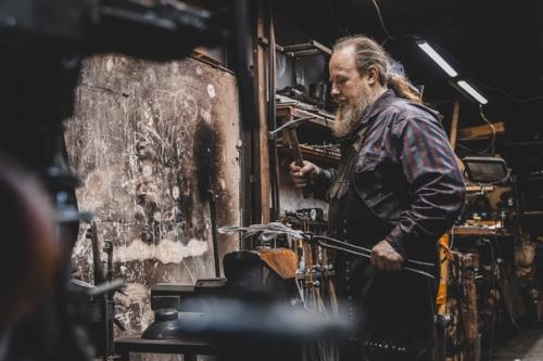 На фото Михаил Авдеев, кузнец в мастерской Кречет. 02