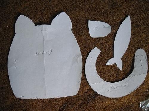 Котики.   Материалы:  - Ткань (хлопок), - нитки, - холофайбер, - ленты, - бусины, - картон, - фольга от шоколада, - акриловые краски по ткани. 01