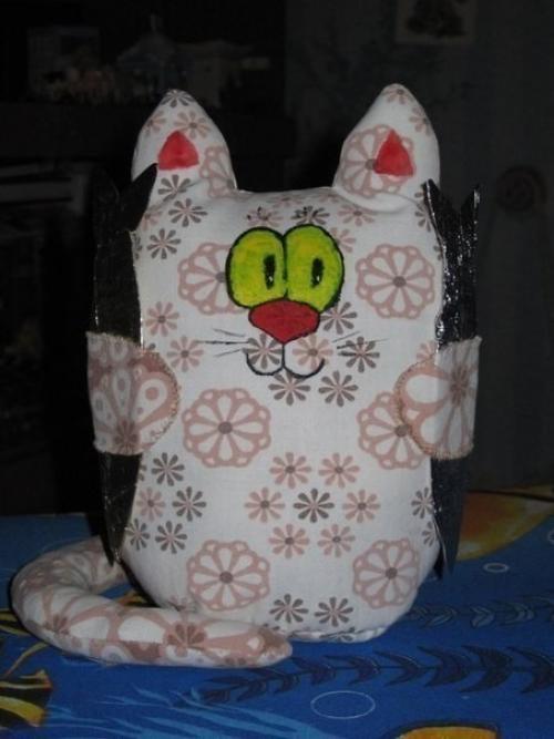 Котики.   Материалы:  - Ткань (хлопок), - нитки, - холофайбер, - ленты, - бусины, - картон, - фольга от шоколада, - акриловые краски по ткани. 02